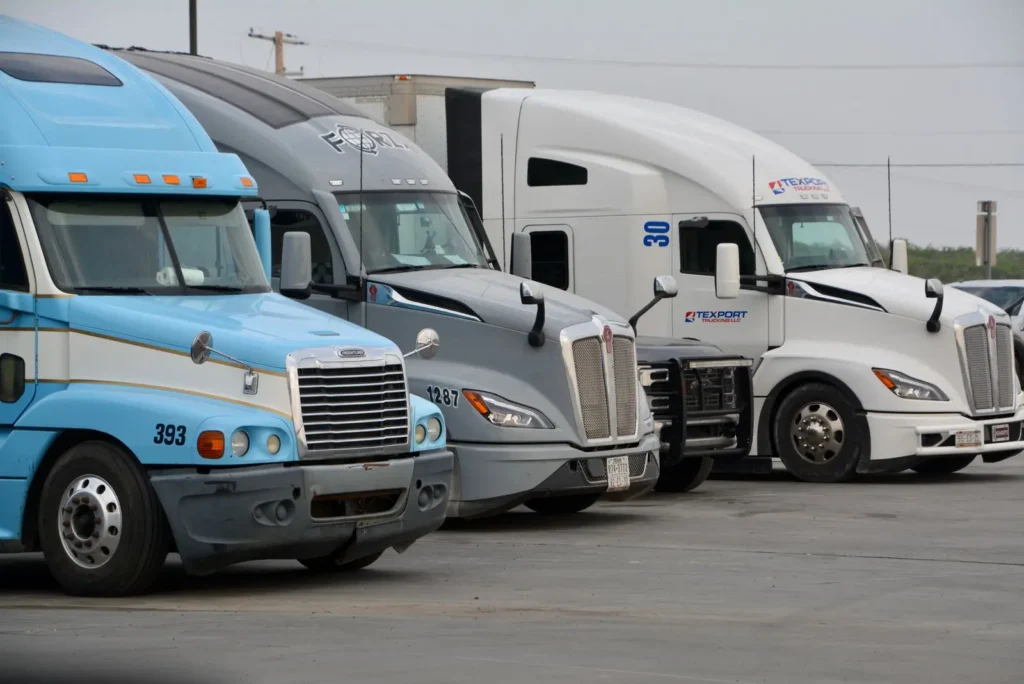 Commercial semi-trucks parked together at a truck stop