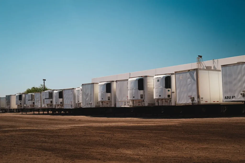 Row of refrigerated semi-trailers parked outside a distribution facility