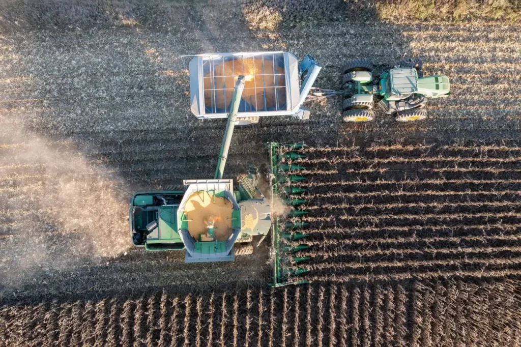 Aerial view of a combine harvesting grain into a tractor trailer