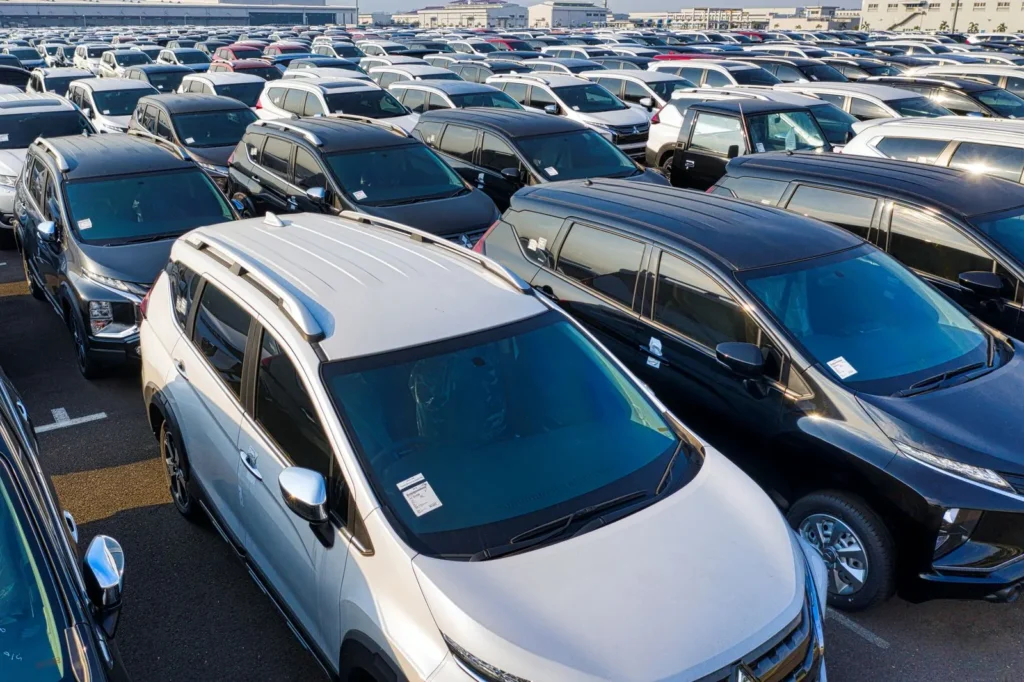 New passenger vehicles lined up in an automotive storage lot