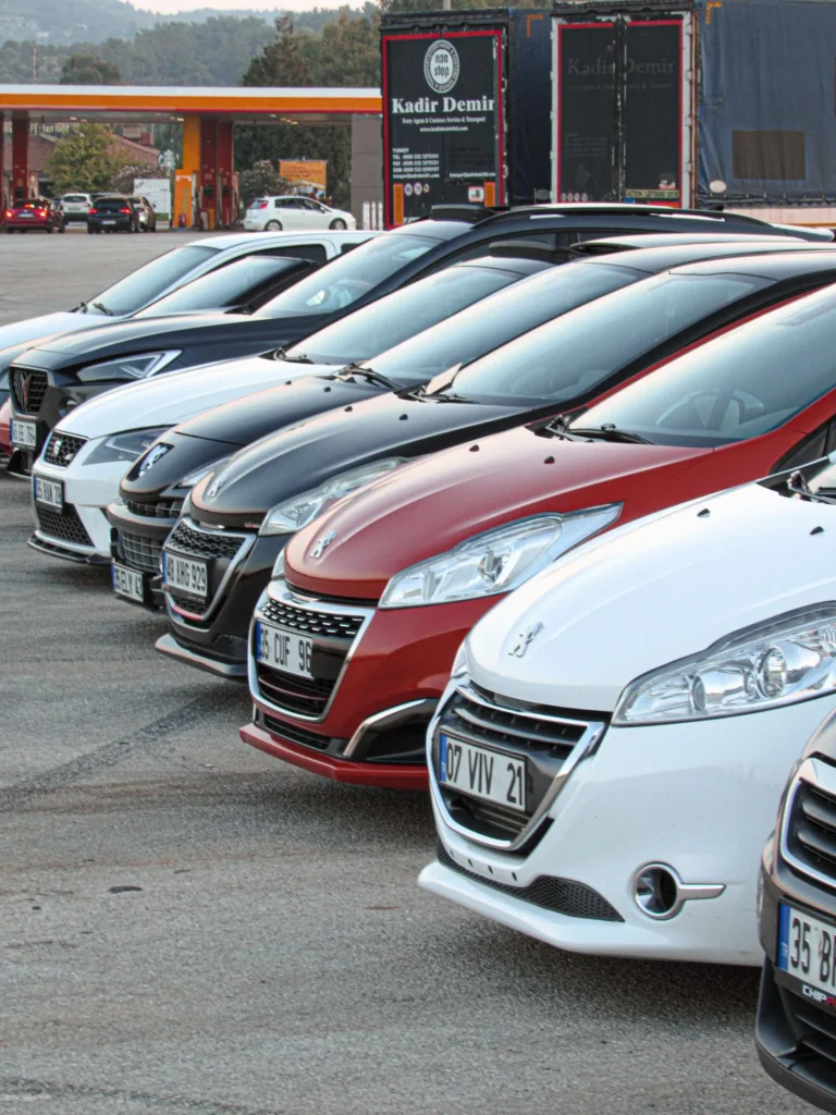 Passenger cars parked in a row at an automotive dealership