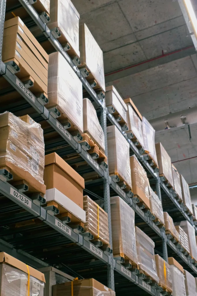 Wrapped pallets of cartons stored on warehouse shelves