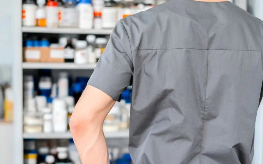 Healthcare worker standing in front of shelves of pharmacy products