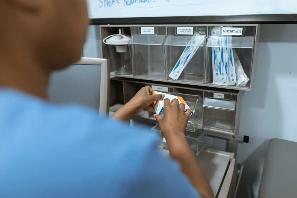 Healthcare worker organizing packaged medical supplies in storage bins