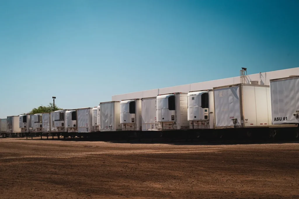 Row of refrigerated semi-trailers parked outside a distribution facility