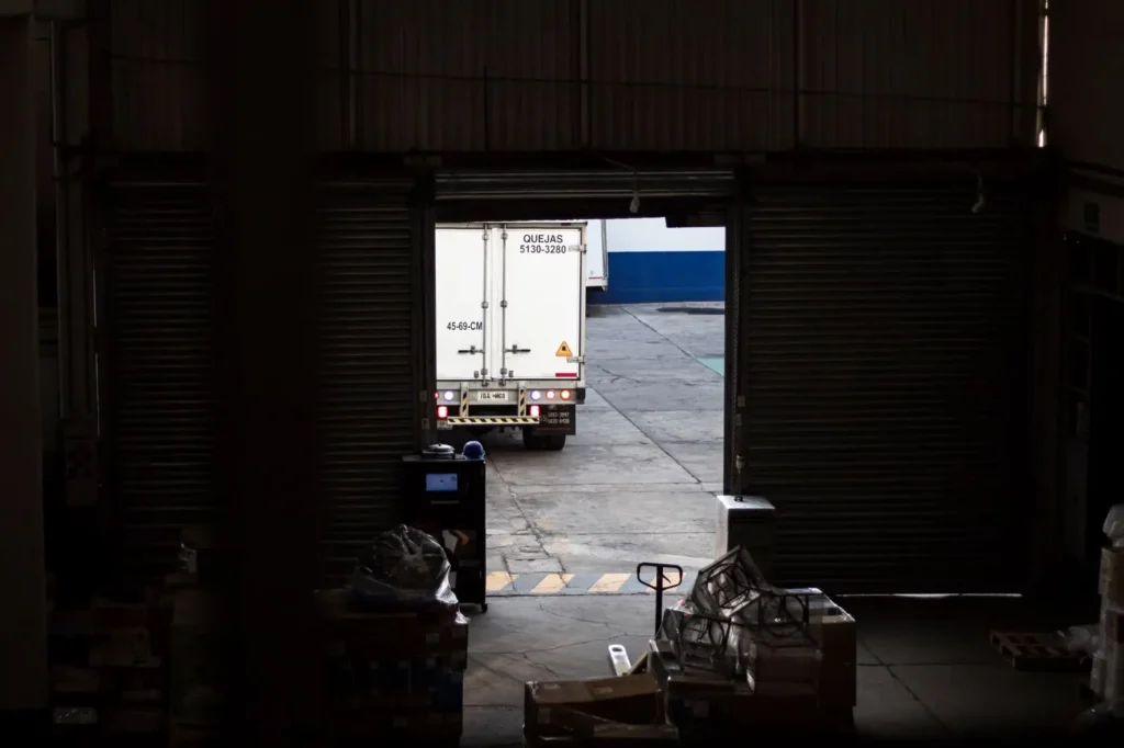 Freight truck seen through an open warehouse loading door