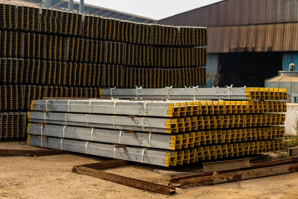 Stacked metal beams in an outdoor industrial yard